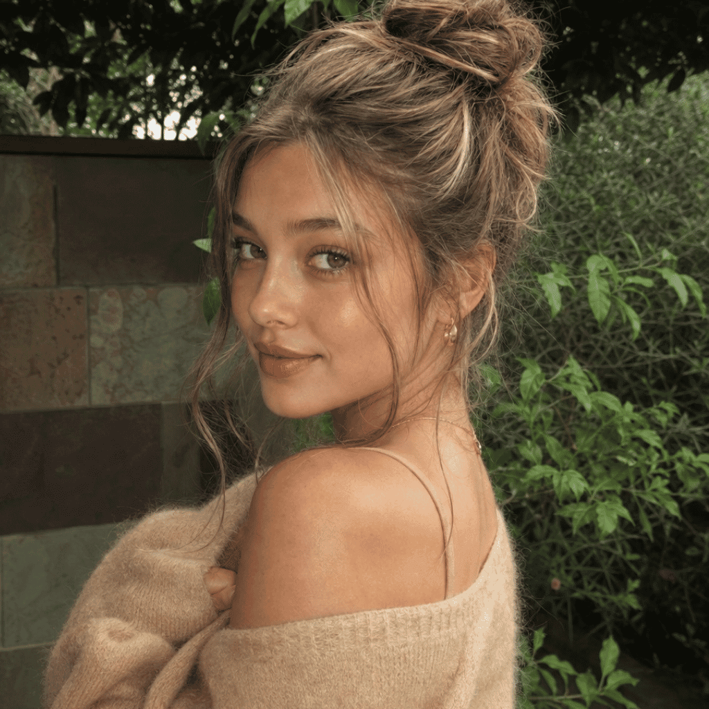 Close-up of a woman looking over her shoulder, demonstrating glossy, warm bronze-blonde hair in an updo.